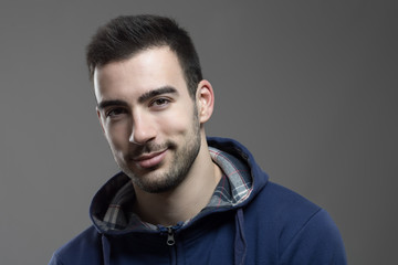 Fototapeta premium Charming young unshaven man smiling at camera with head slanted. 