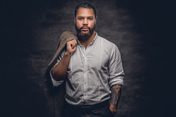 Bearded black man with tattooed arm.