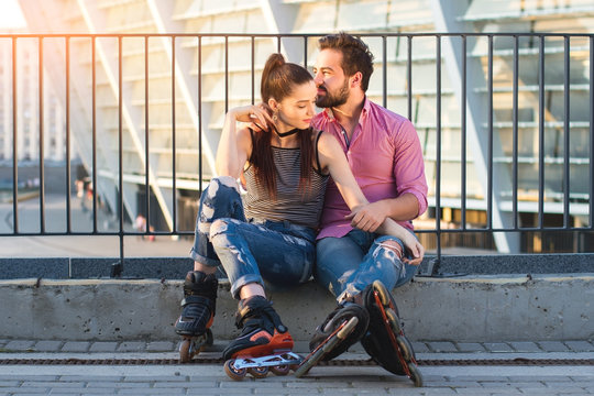 Couple on rollerblades sitting. Two people in the street. Time spent together is priceless.