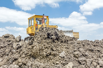 Fototapeta premium Heavy earthmover construction machine is moving earth at buildin