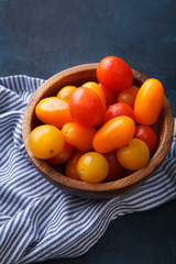 Cherry tomatoes with striped towel on blue background