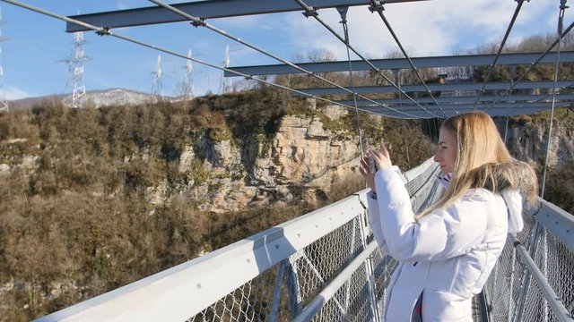 Woman take photos of the scenery nature views on the skybridge over the canyon