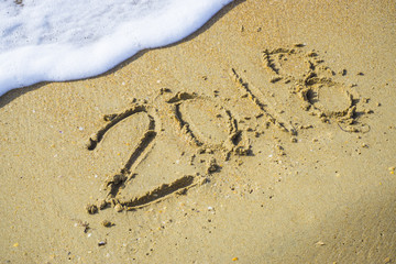 Abstract 2018 on a beach sand background