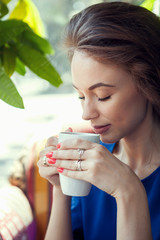 Beautiful woman drinking coffe in a cafe and looking down