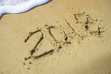 Abstract 2018 on a beach sand background