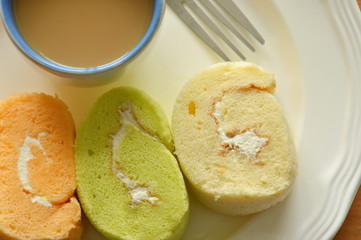 assorted jam roll and coffe cup with fork on dish