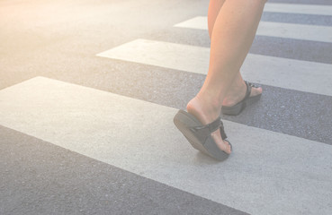 A woman crossing a crosswalk