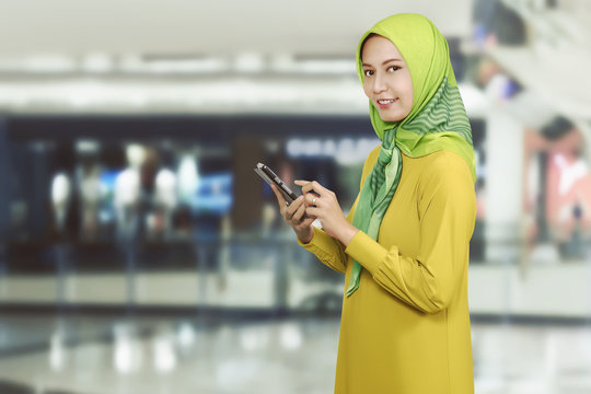 Pretty asian muslim female with mobile phone