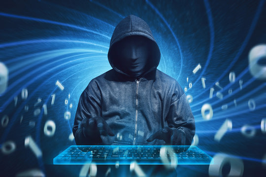 Hooded hacker with mask typing on virtual keyboard