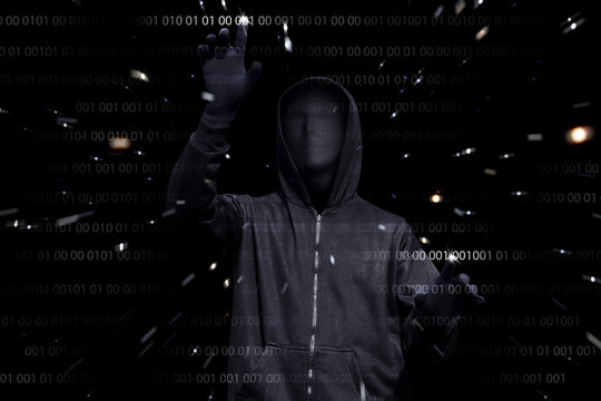 Hooded man with anonymous mask hacking binary system security code