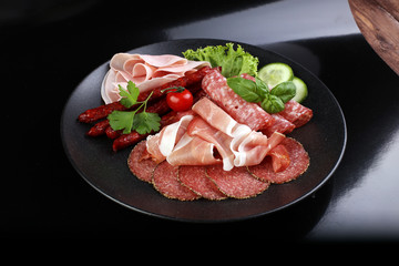 Food tray with delicious salami, pieces of sliced ham, sausage,