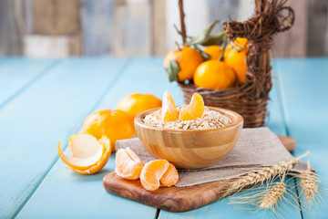 oat flakes and tangerines on a table, selective focus, copy space