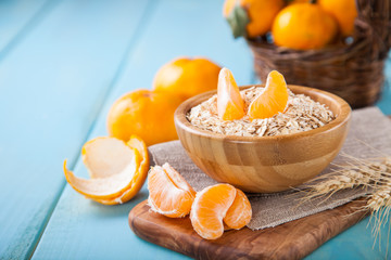oat flakes and tangerines on a table, selective focus, copy space