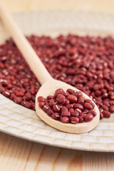 Raw uncooked adzuki red beans in wooden spoon