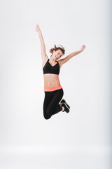 Fototapeta premium Happy young fitness woman jumping