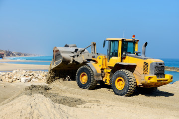 Fototapeta na wymiar bulldozer working on a beach