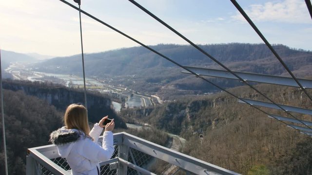 Woman take photos of the scenery nature views on the skybridge over the canyon