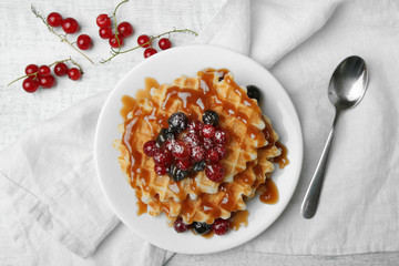 Baked waffles with fresh berries on the plate. Breakfast.