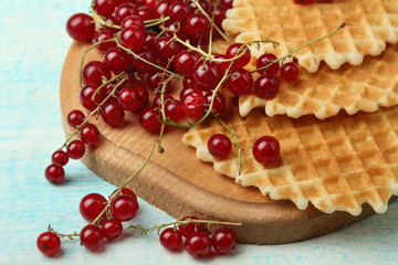 Baked waffles with fresh berries on a blue wooden background. Breakfast.