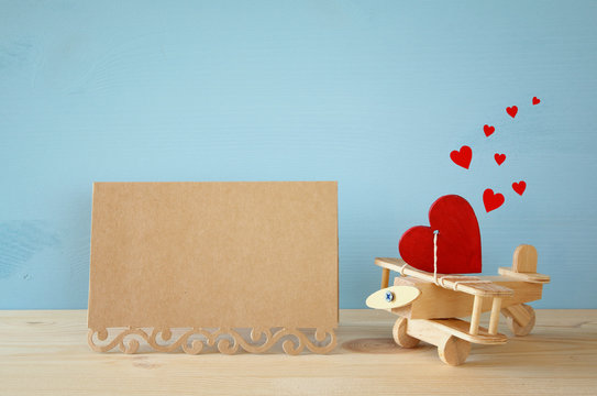 Wooden plane with heart next to blank creeting card