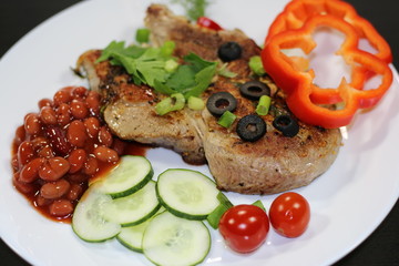 Baked steak with vegetable garnish on a black background