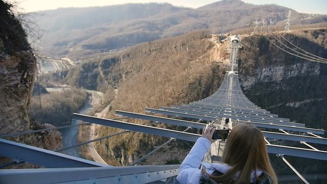 Woman take photos of the scenery nature views on the skybridge over the canyon