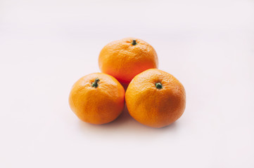 three delicious juicy tangerines on a white background