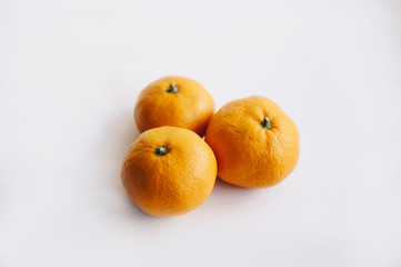 three delicious juicy tangerines on a white background