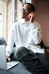 Handsome african businessman talking by phone. Coworking.