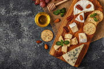 Assortment of cheese with wine, honey, nuts and grape.