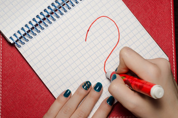 The girl heart drawing a marker in a notebook for Valentine Day.