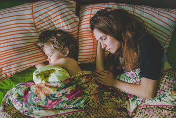 Мама и сын ребёнок спят на кровати