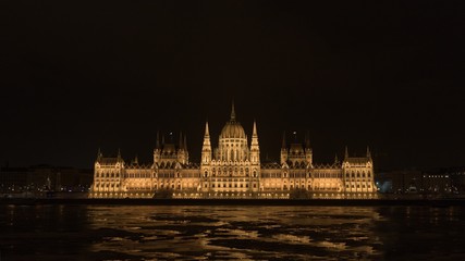 Fototapeta premium Parliament at nighttime with icy Danube
