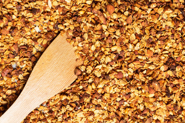 Granola in a pan on a wooden brown background, horizontal, soft focus