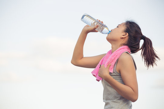 portrait of young woman drinking water after sporting