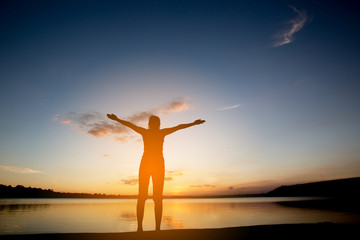 Fototapeta premium Silhouette woman with yoga posture at sunset.
