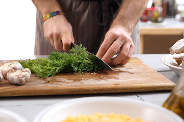 Kucharz kroi koper. Dłonie kucharza siekającego warzywa na desce kuchennej - obrazy, fototapety, plakaty