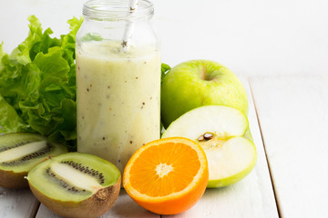 green smoothie in a glass bottle with the ingredients