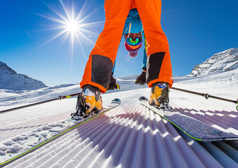 Skier posing on piste in high mountains