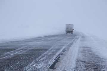 Car on winter road in a snowstorm and bad visibility