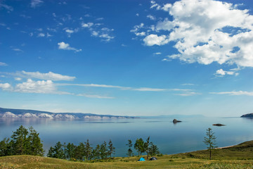 Two tents on the coast of beautiful lake surrounded by mountains