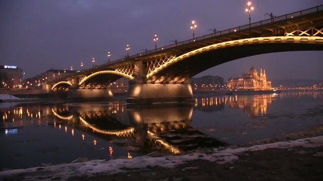 Budapest landscape during the ice debacle on the river danube. We can see as the pieces if ice slowly floating down the river under the beautiful view of the city with the bridge and parliament