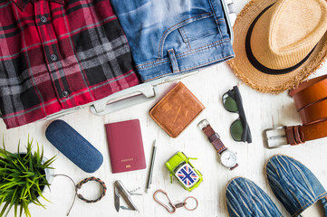 Travel preparations, men's casual outfits with accessories on white rustic wooden background