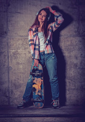 Obraz na płótnie Canvas Beautiful young woman with skateboard outdoors