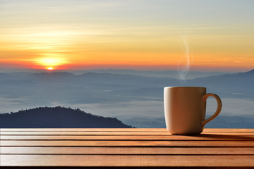 Morning cup of coffee or tea with mountain background at sunrise - obrazy, fototapety, plakaty