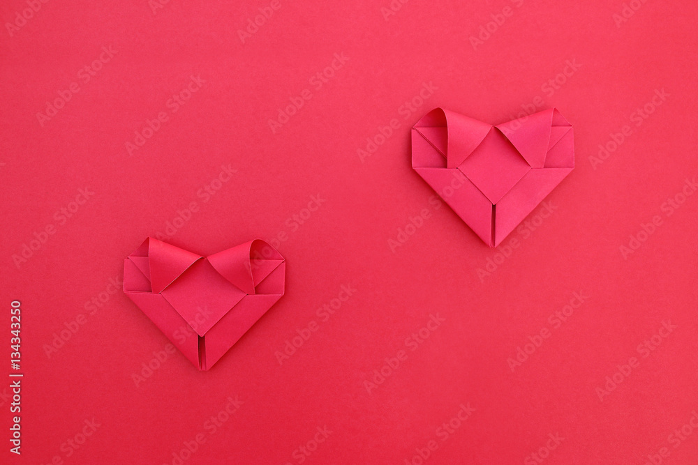 Poster two folding red paper separated hearts on red for pattern and ba