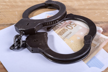 Handcuffs and euro bills