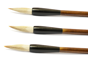Set of three Chinese calligraphy brushes over a white background
