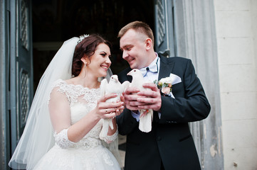 Happy smiled wedding couple with doves on hands after wedding re