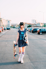young beautiful asian millennial woman nonconformist walking outdoor in the city listening music with headphons and smart phone hand hold, holding skater - music, sportive, technology concept